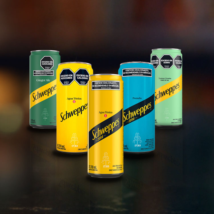 Cinco latas de diferentes colores y sabores de Schweppes están dispuestas contra un fondo oscuro y desenfocado. Los sabores incluyen Ginger Ale, Agua Tónica, Agua Tónica Zero, Agua Tónica Limón y gaseosa de Pomelo.