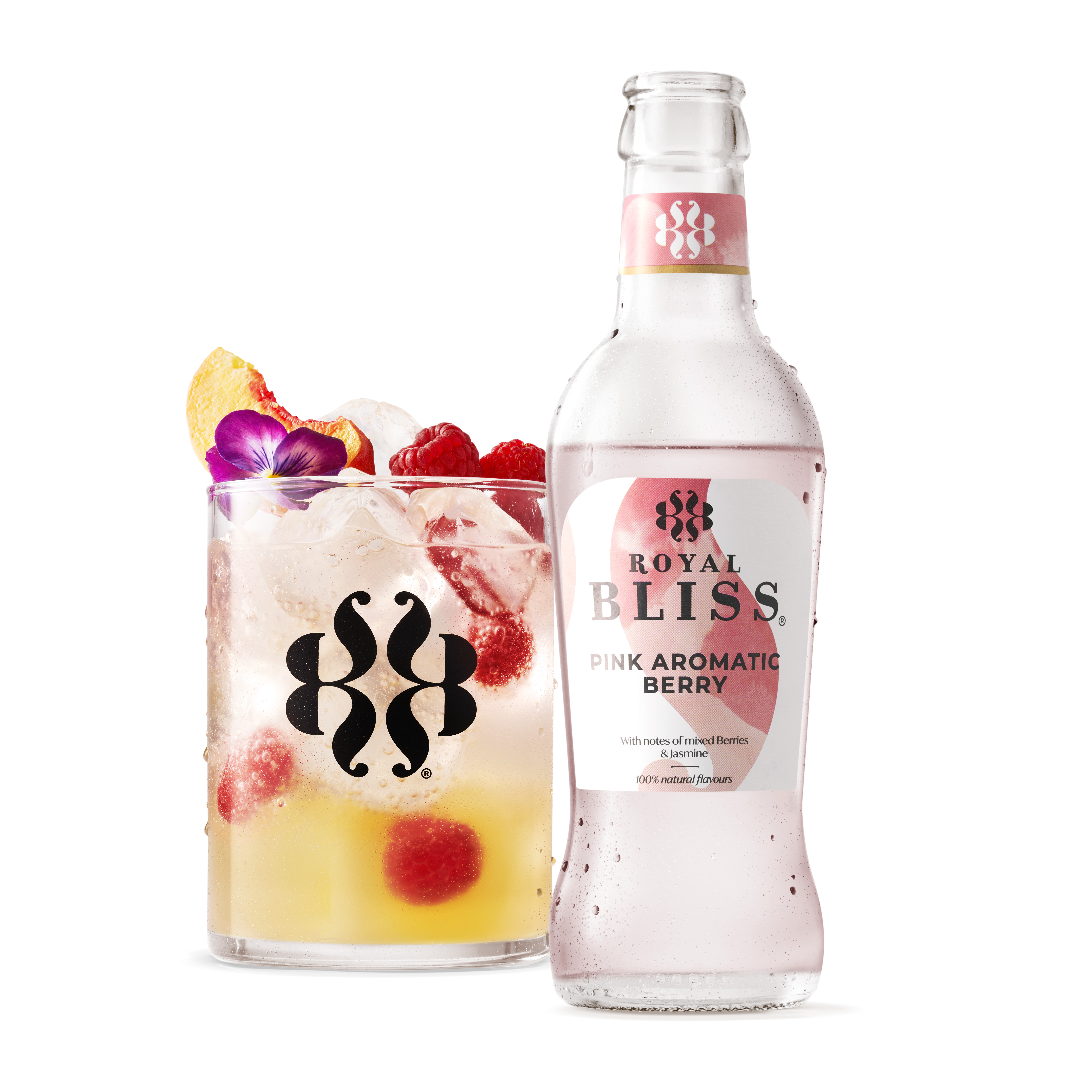 Bouteille transparente « ROYAL BLISS – Pink Aromatic Berry » contenant un liquide rose très pâle, avec étiquette rose et blanche et logo noir stylisé en haut. Texte sous le nom : « With notes of mixed berries & jasmine – 100% natural flavours ». À gauche, un verre rempli de boisson pétillante jaune clair, avec de gros glaçons, framboises entières, un quartier de pêche, et décoré d’une petite fleur violette sur le dessus.