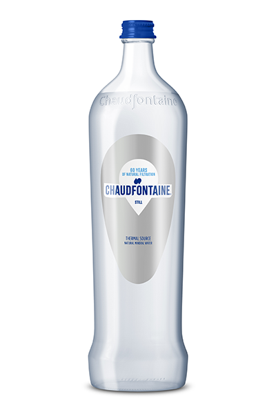 Doorzichtige glazen fles Chaudfontaine natuurlijk mineraalwater zonder bruis, met blauwe dop en etiket met de tekst « 60 years of natural filtration – Still ».