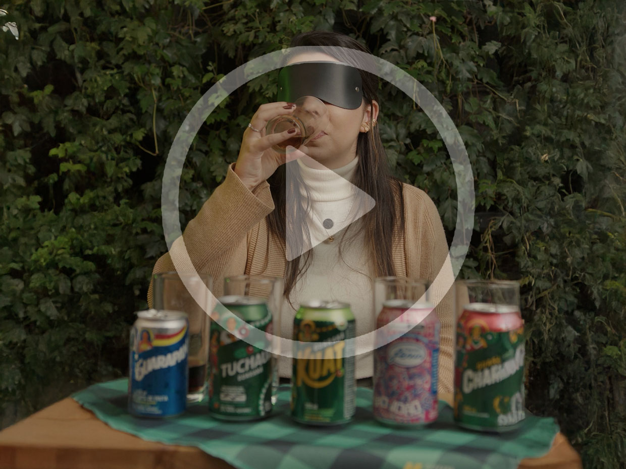 Menina experimentando diferentes sabores de guaraná, com os olhos tapados