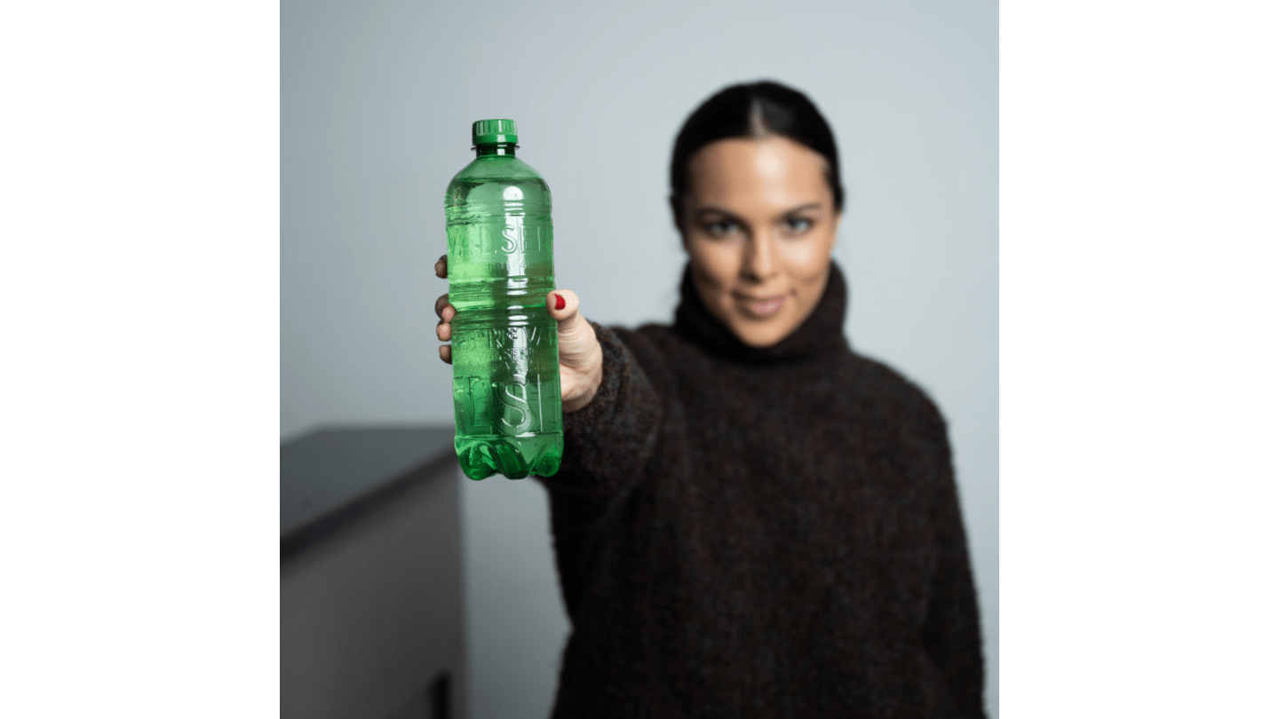Frau hält Valser-Flasche ohne Etikett