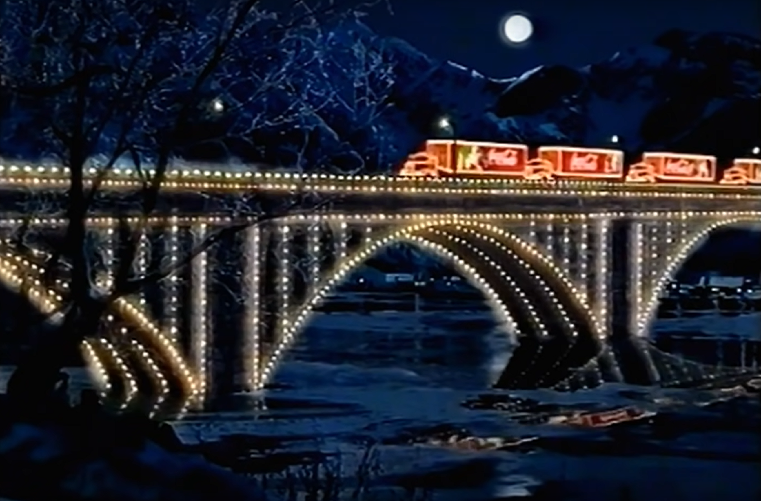 Eine Christmastruck Kolone, die über eine beleuchtete Brücke fährt.
