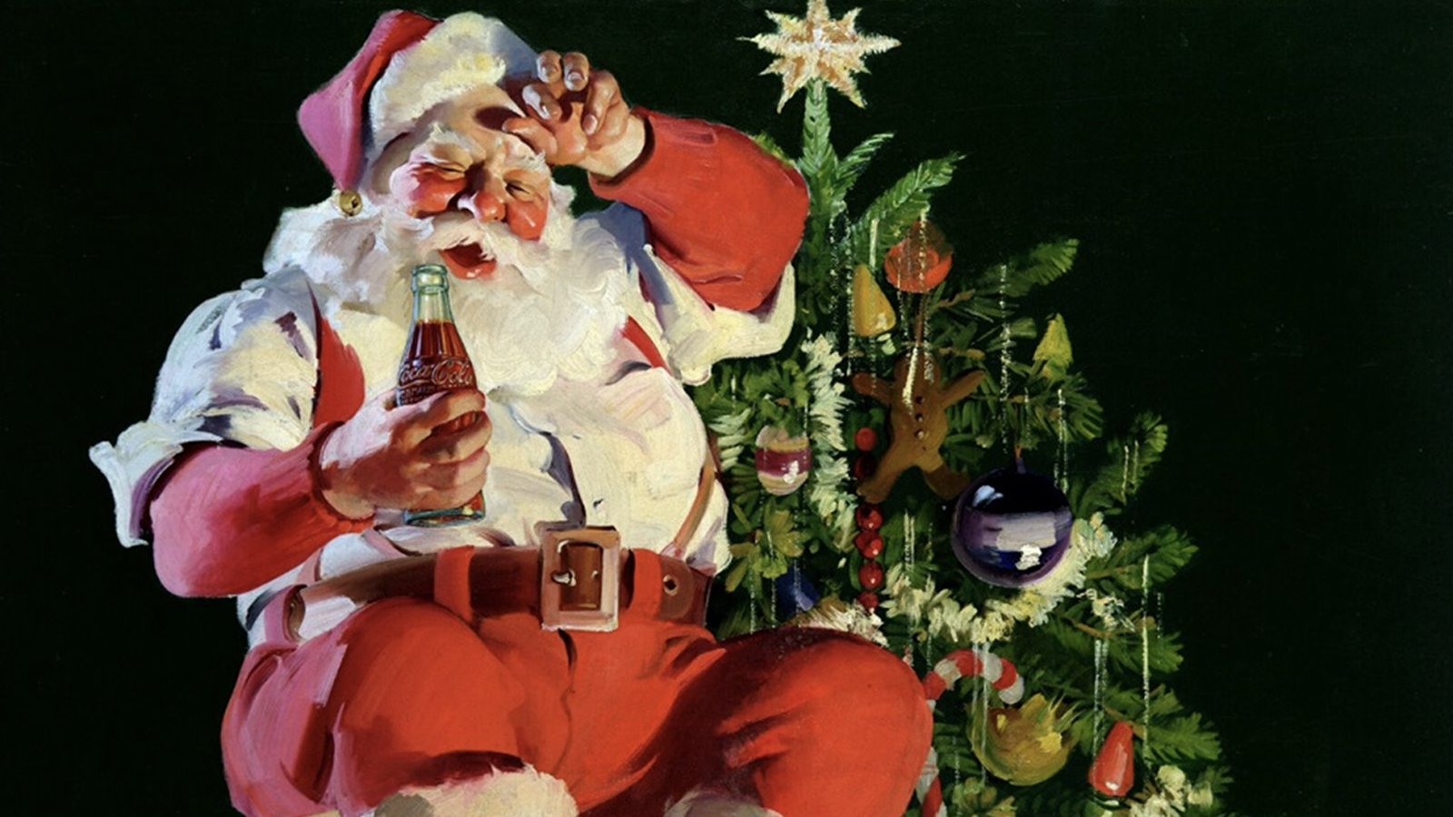 Le Père Noël boit un Coca-Cola à côté d'un sapin de Noël.