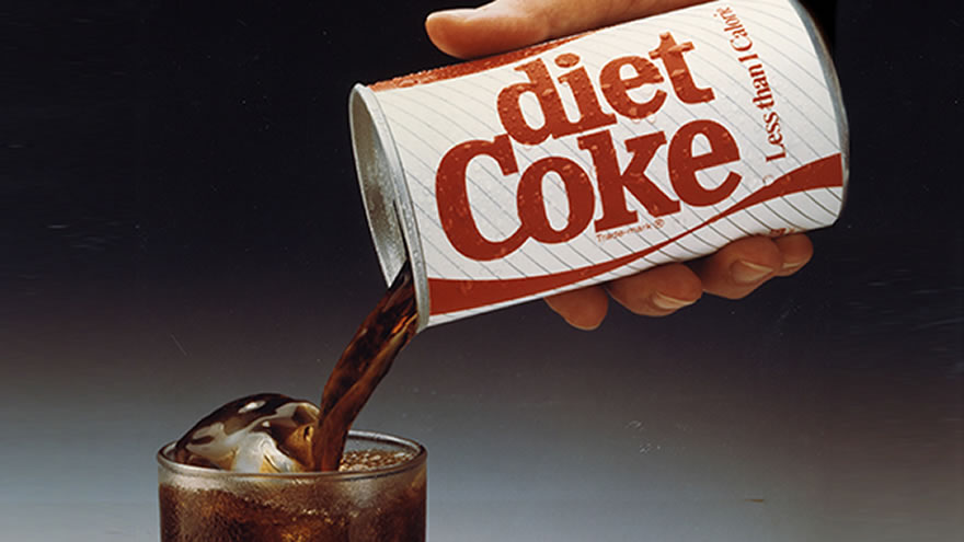 Main versant une canette de Diet Coke dans un verre.