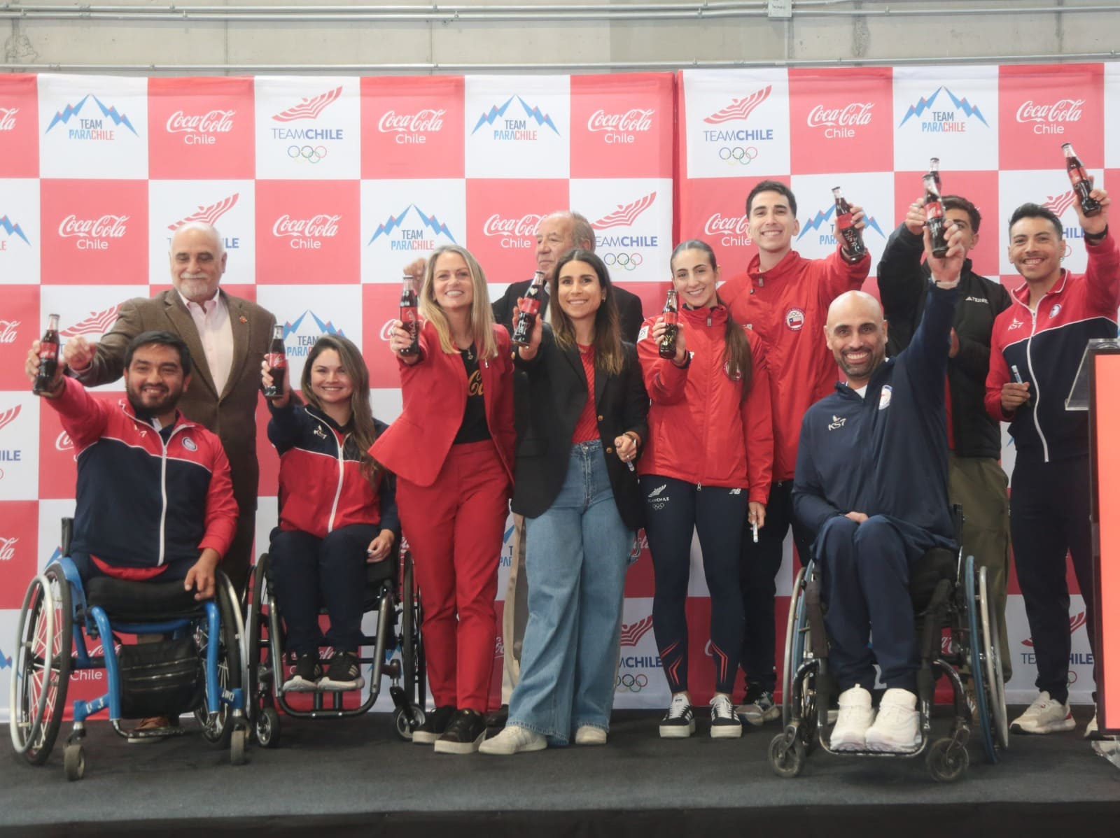 Grupo de atletas de Chile haciendo un brindis con botellas de Coca-Cola de vidrio