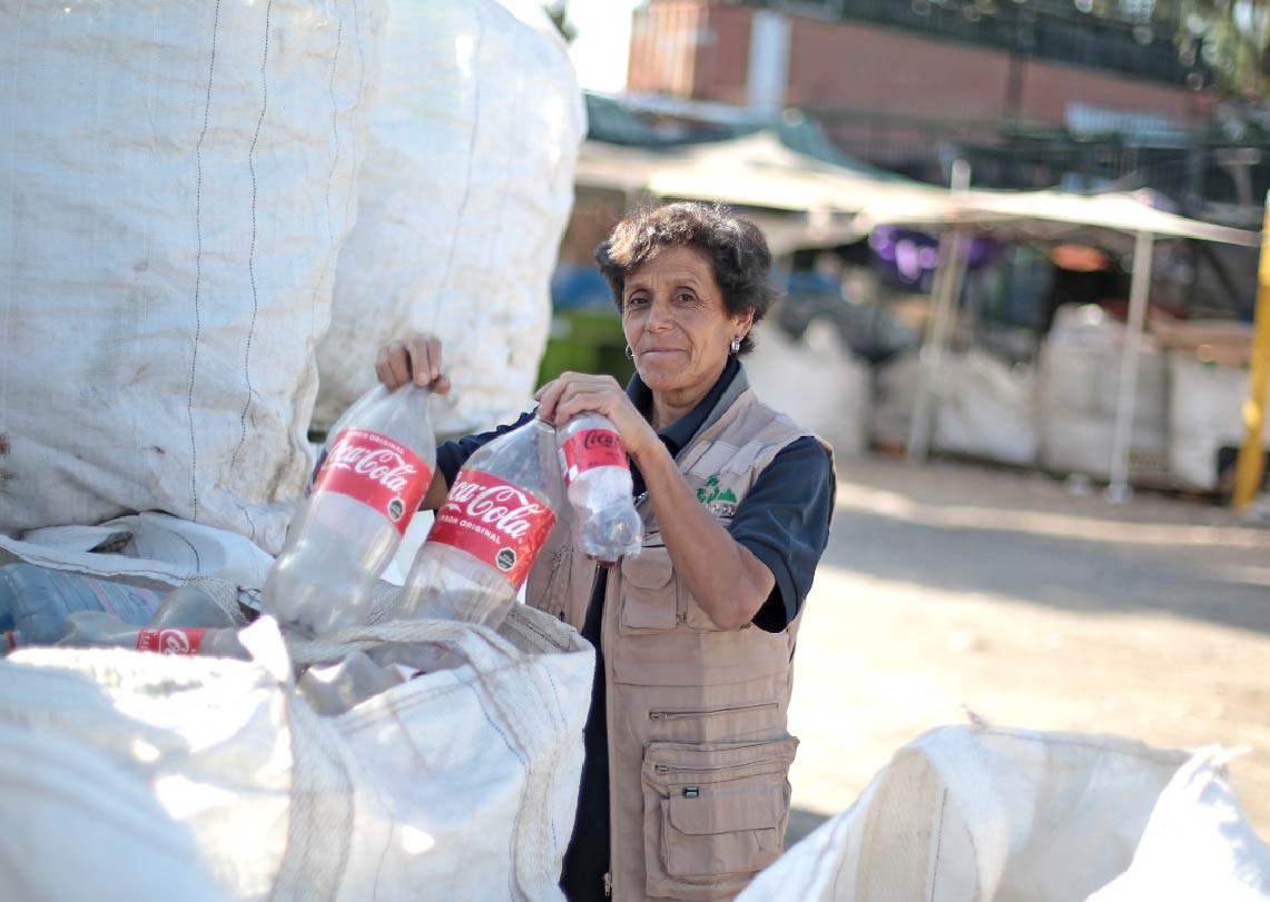 Trabajadora en Chile clasificando botellas plásticas para reciclaje en centro de acopio