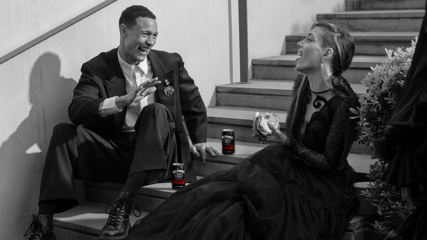 People sat on steps enjoying a Jack Daniel's and Coca-Cola