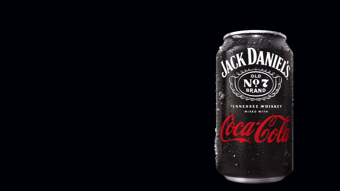 Krabička s koktejlem Jack Daniel's a Coca-Cola na černém pozadí s kapkami vody.