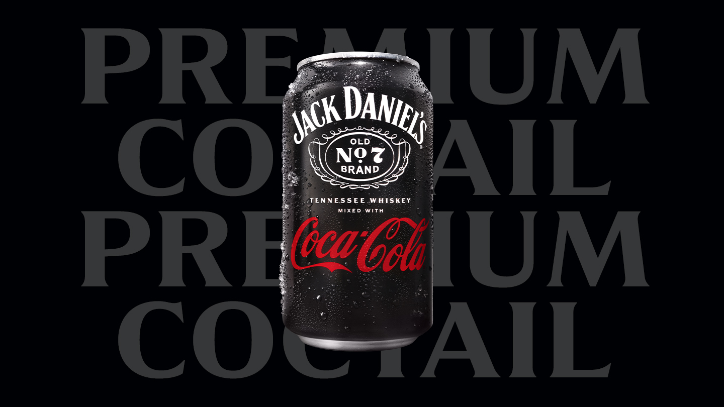 Prémiový koktejl Jack Daniel's a Coca-Cola v černé krabičce s kapkami ledu.