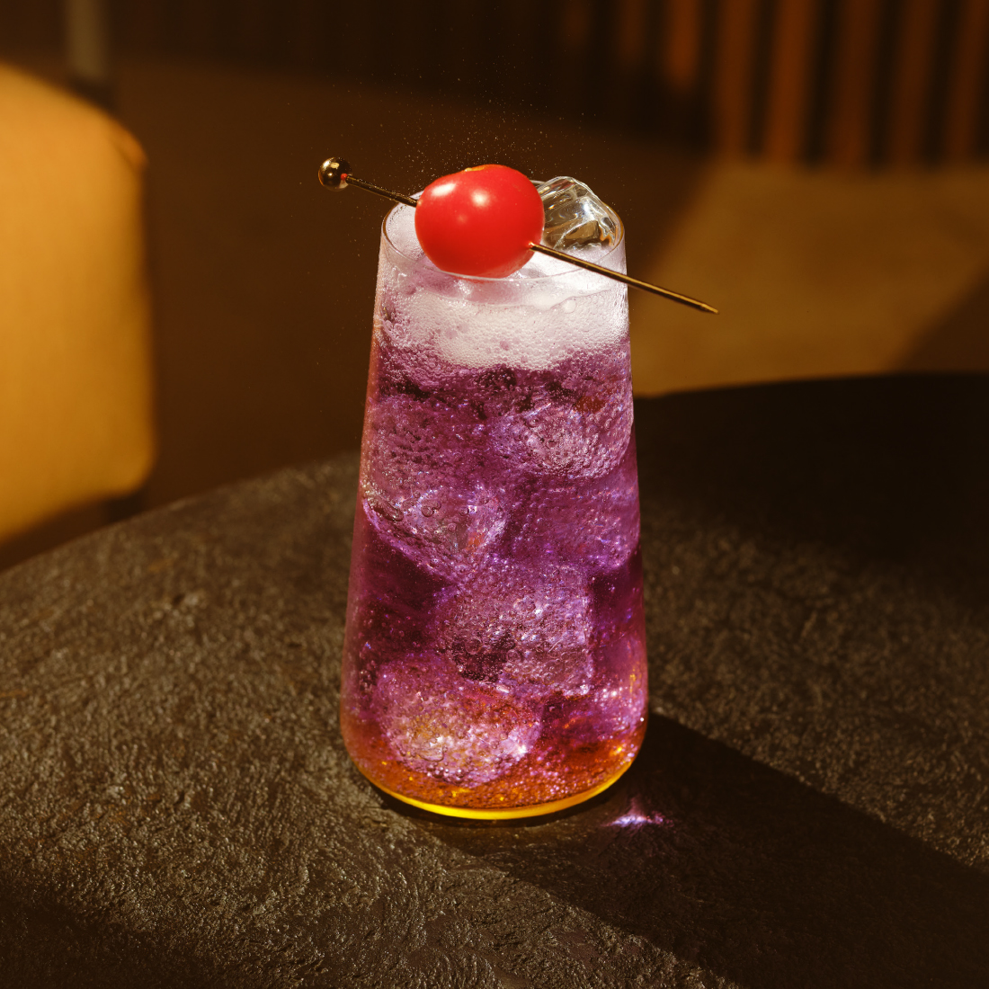 a glass of schweppes passion fruit highball on a table