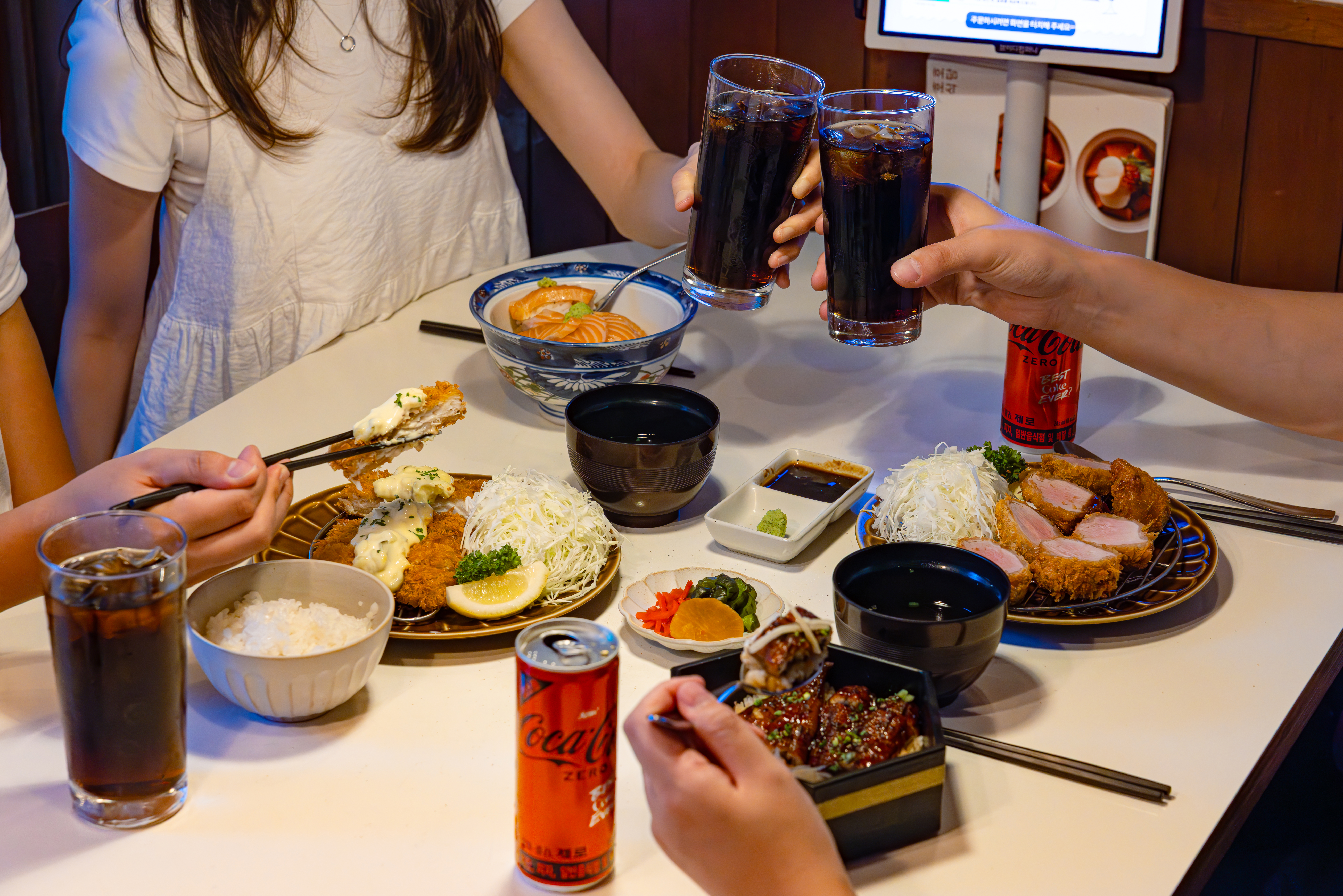 ‘호호식당’의 대표메뉴들과 새로워진 코카-콜라 제로를 즐기고 있다.