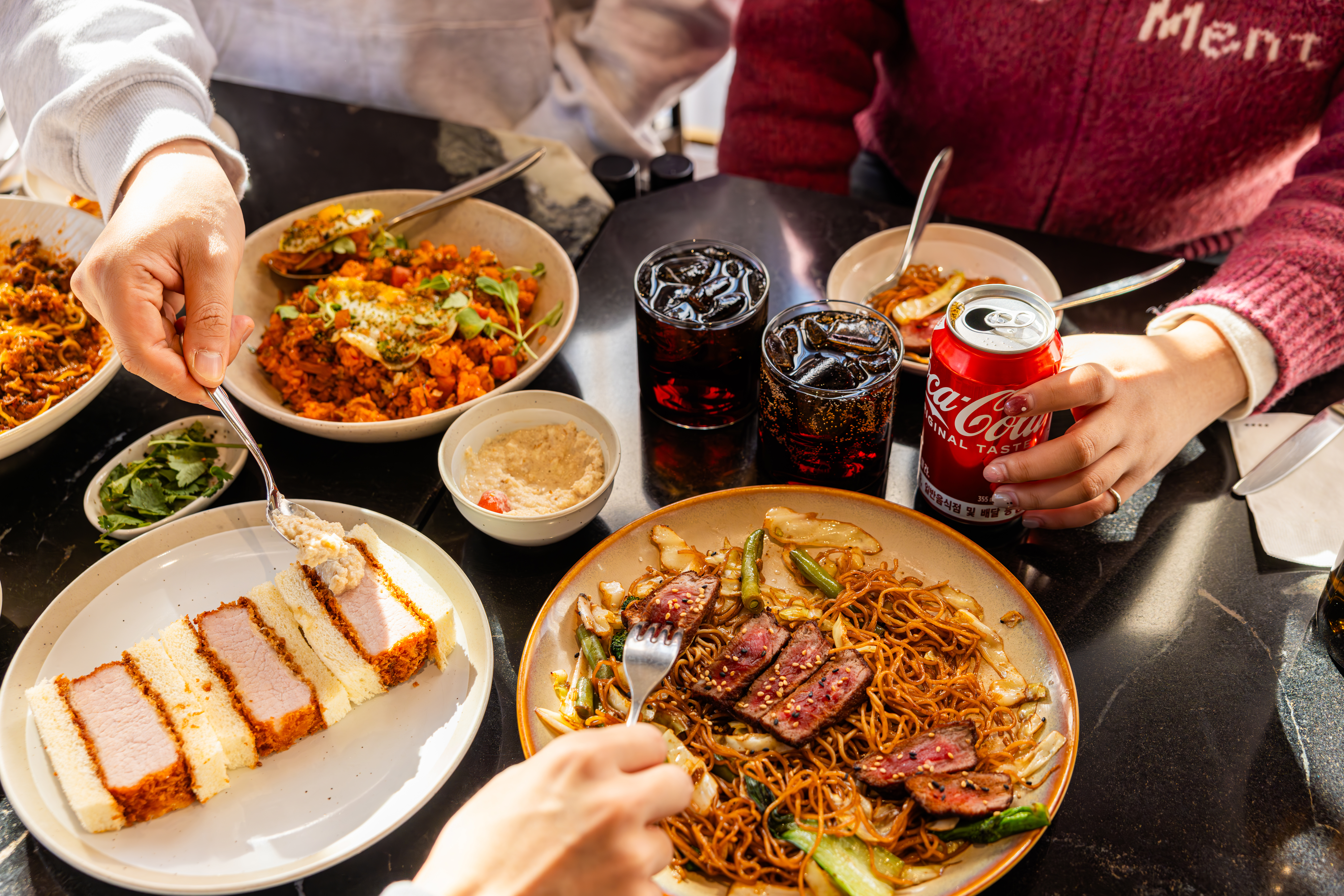 한남동 레드리본 맛집, 다츠의 대표메뉴, 다츠 시그니처 가츠산도, 스테이크 차우미엔, 다츠 김치볶음밥을 코카-콜라와 함께 즐기고 있는 사진
