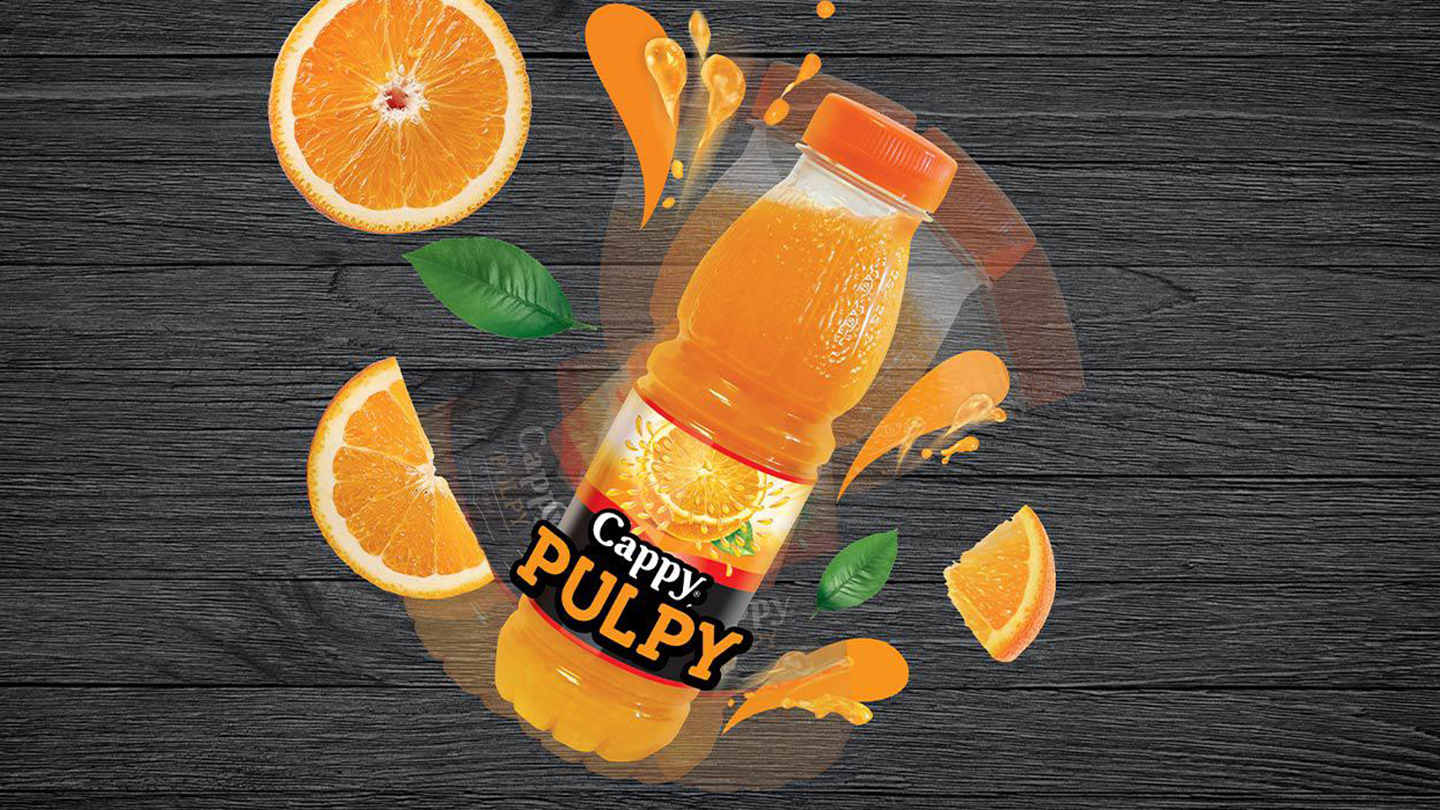 Sticlă de Cappy Pulpy de portocale, cu felii și frunze de porticale în jur