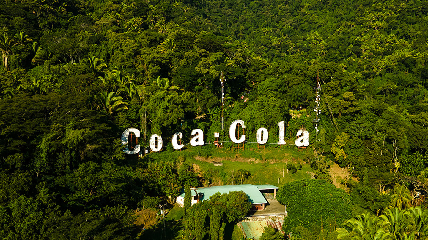 Logo e Coca-Cola në pyll.