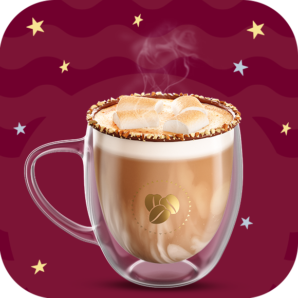 Una taza de cristal con café moka caliente y bombones rostizados por encima con nuez picada decorando los bordes de la taza sobre un fondo en tonos guinda.