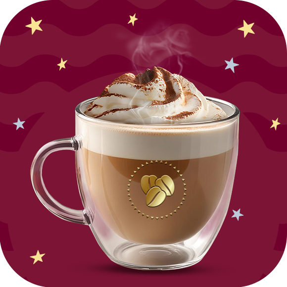 Una taza de cristal con cinnamon latte caliente y crema batida por encima decorado con canela en polvo por encima sobre un fondo en tonos guinda.