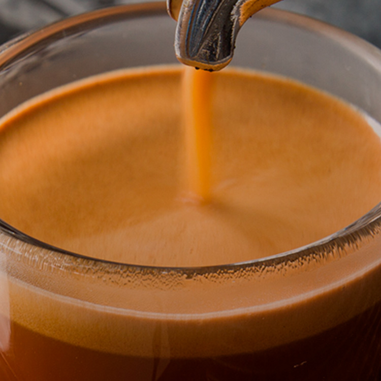 Cafetera sirviendo una taza de café espresso.