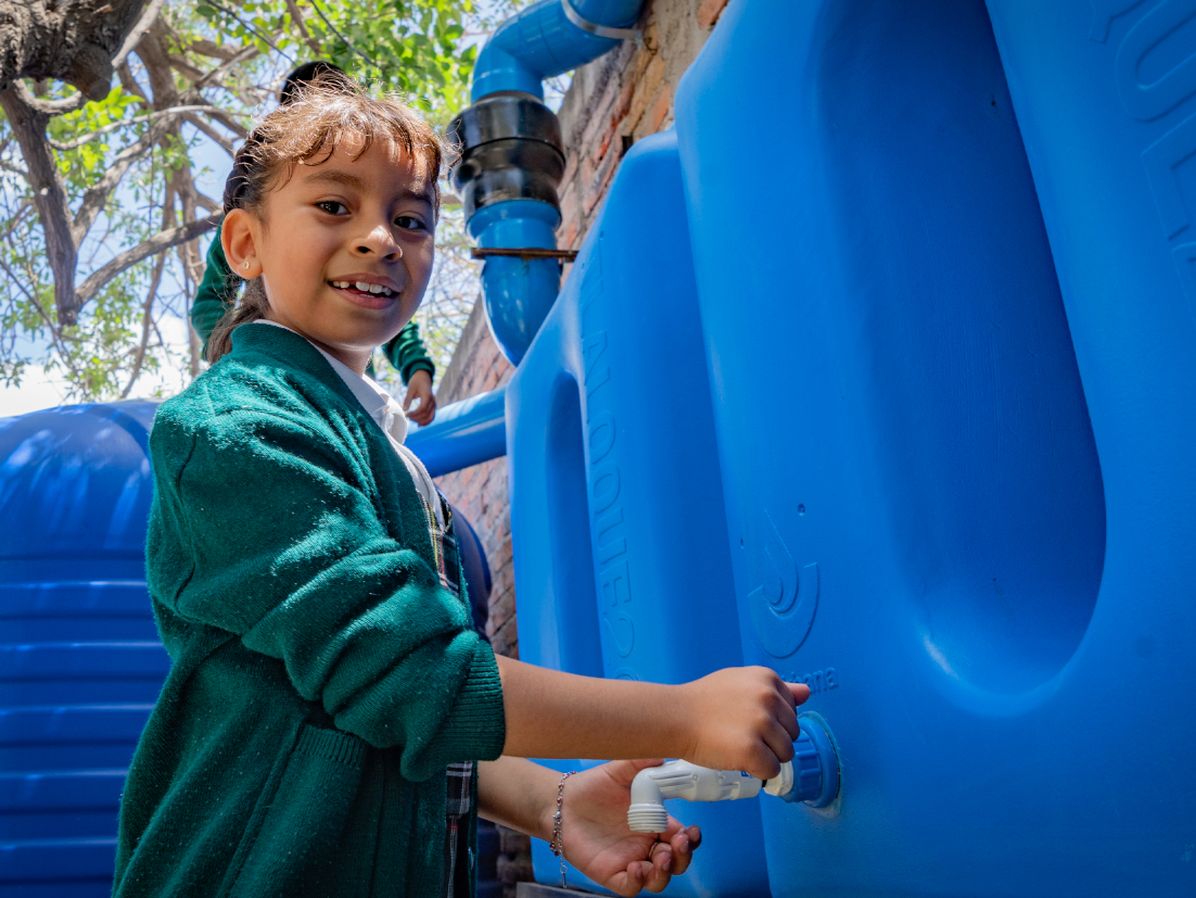 Imagen de una niña abriendo una canilla de agua.